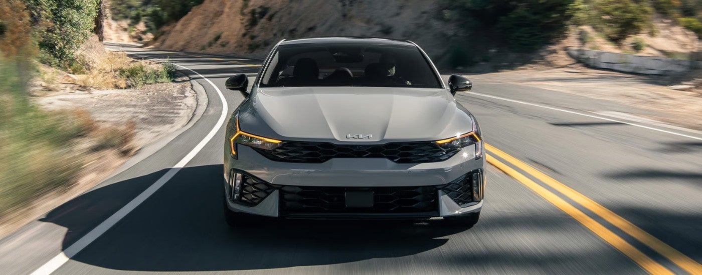 A grey 2025 Kia K5 from the front.